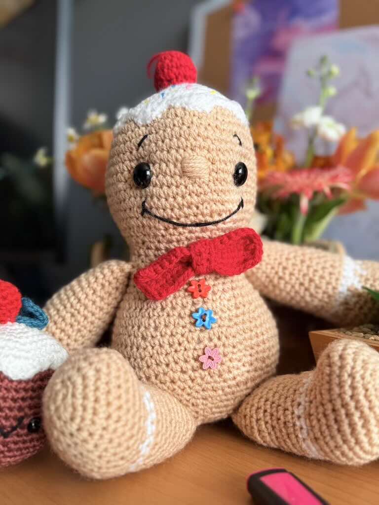 handmade crochet gingerbread man with smiling face and candy details