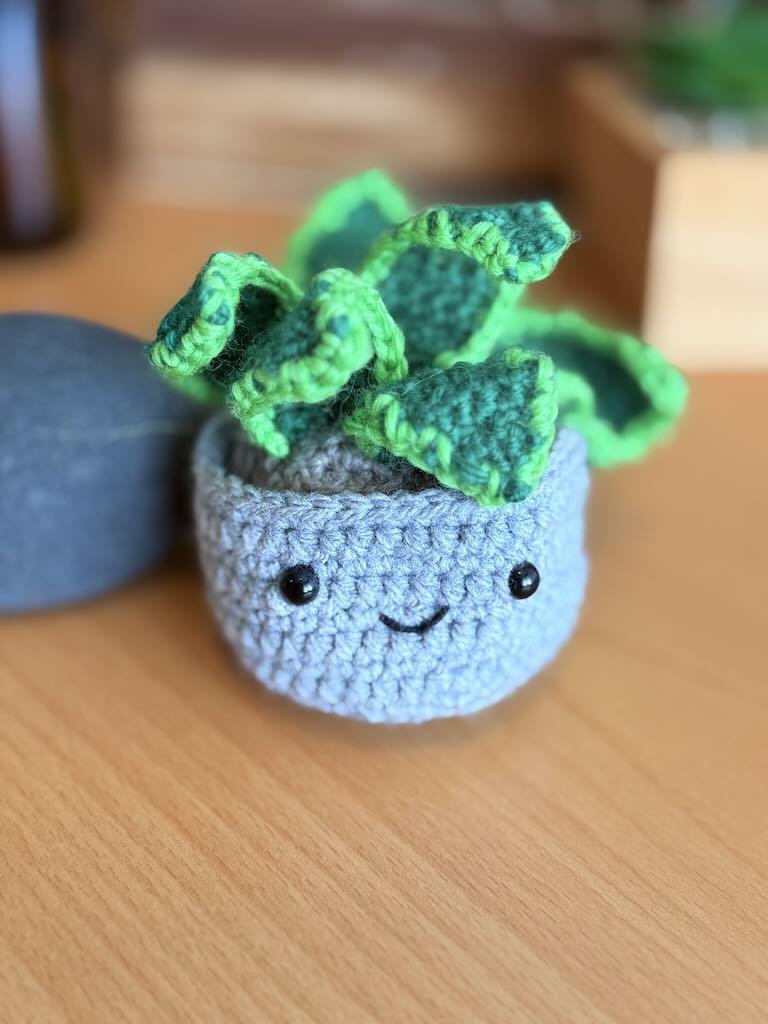 handmade crochet snake plant in a small pot with tall green leaves