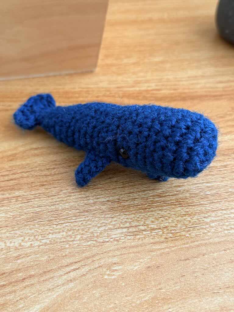 handmade crochet mini whale named Bluey with blue yarn and friendly smile