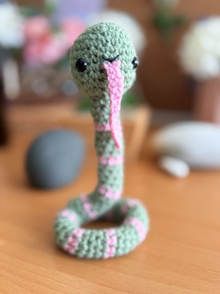 handmade crochet snake toy named Slither with long body and playful face